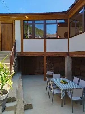 a patio with a table and chairs on a building at Casa Rural Xures Lobios in Ourense