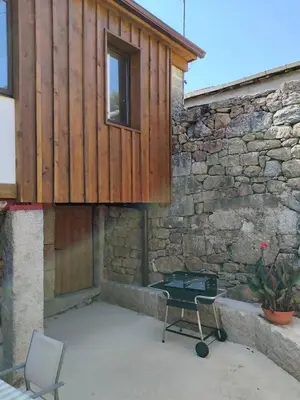 a building with a table and a chair in front of it at Casa Rural Xures Lobios in Ourense