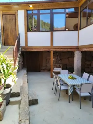 a patio with a table and chairs in a house at Casa Rural Xures Lobios in Ourense