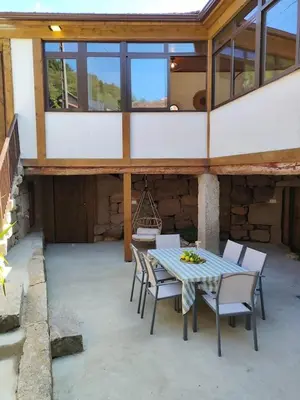 a patio with a table and chairs in a building at Casa Rural Xures Lobios in Ourense