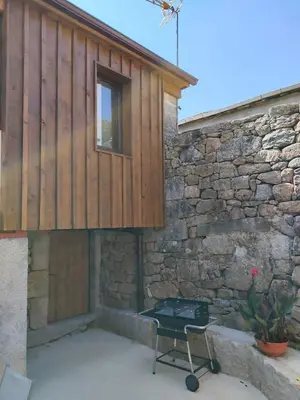 a barbecue grill in front of a stone building at Casa Rural Xures Lobios in Ourense