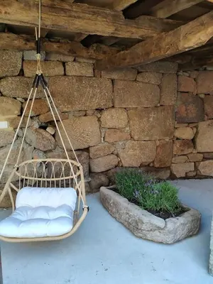 a swing hanging in front of a stone wall at Casa Rural Xures Lobios in Ourense