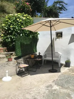 a patio with an umbrella and a table and chairs at Casa Pataco in Cangas del Narcea