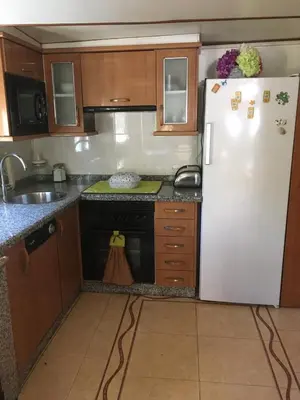 a kitchen with a white refrigerator and a sink at Casa Pataco in Cangas del Narcea