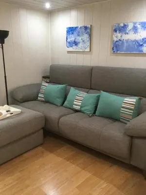 a living room with a couch with pillows on it at Casa Pataco in Cangas del Narcea
