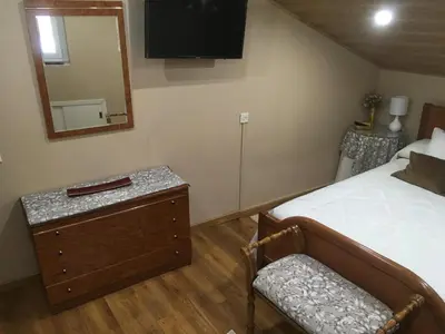 a bedroom with a bed and a mirror and a chair at Casa Pataco in Cangas del Narcea