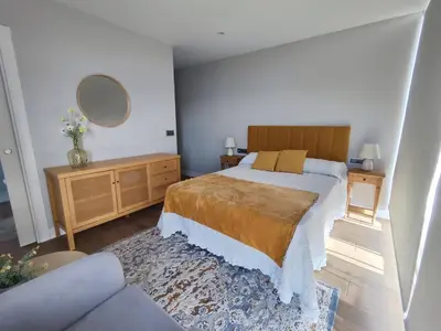 a bedroom with a bed and a couch and a mirror at Villa Quelle in Sieiro