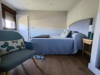 a small bedroom with a bed and a chair at Villa Quelle in Sieiro