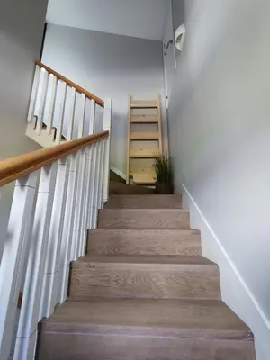 a stairway with white walls and wooden stairs at Villa Quelle in Sieiro