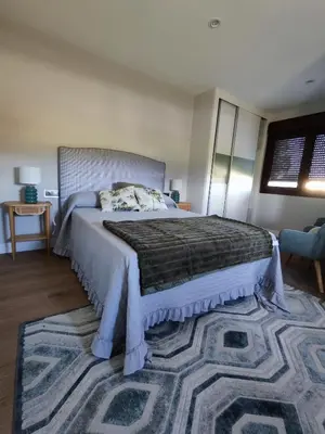 a bedroom with a large bed and a rug at Villa Quelle in Sieiro