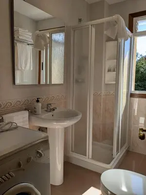 a white bathroom with a shower and a sink at Playa de Miño in Miño