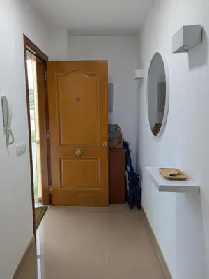 a bathroom with a wooden door and a white wall at Playa de Miño in Miño