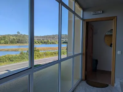 a room with a window looking out at a river at Playa de Miño in Miño