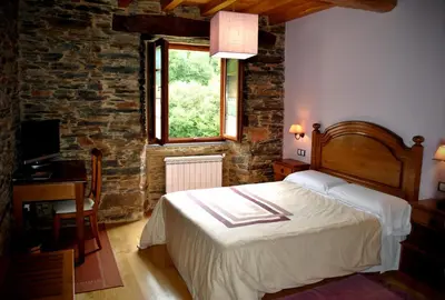 a bedroom with a large bed and a window at Finca O Bizarro in Trabada