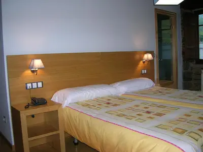 a bedroom with a large bed and a wooden headboard at Finca O Bizarro in Trabada