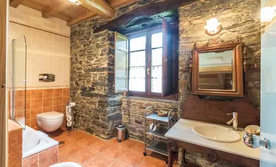 a bathroom with a sink and a toilet and a window at Finca O Bizarro in Trabada