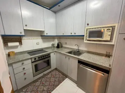 a kitchen with white cabinets and a sink and a microwave at Bierzo Explore in Ponferrada