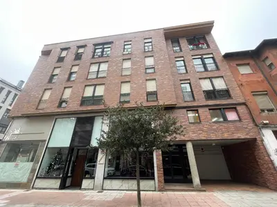 a tall brick building with a tree in front of it at Bierzo Explore in Ponferrada