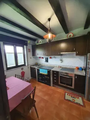 a kitchen with a table and a kitchen with a tableablish at EnSan CIPRIAN Casa Lula in Cervo