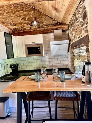 a kitchen with a wooden table with wine glasses on it at CASA BORAL- Comfort exclusivo en plena naturaleza - Valle del Silencio in Manzanedo de Valdueza