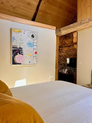 a bedroom with a bed and a painting on the wall at CASA BORAL- Comfort exclusivo en plena naturaleza - Valle del Silencio in Manzanedo de Valdueza