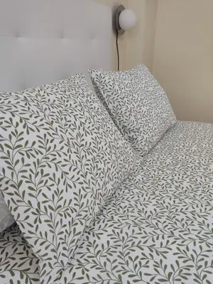a bed with a black and white comforter and pillows at Melide Suites By OL in Melide