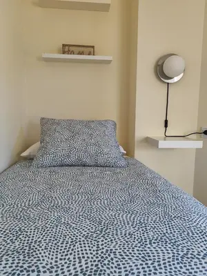 a bedroom with a bed with a blue comforter and a lamp at Melide Suites By OL in Melide
