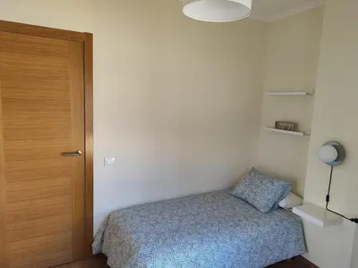a small bedroom with a bed and a wooden door at Melide Suites By OL in Melide