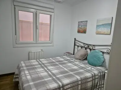 a bedroom with a bed with two pillows and a window at Apartamento céntrico, tranquilo, buenas vistas in Ribadeo