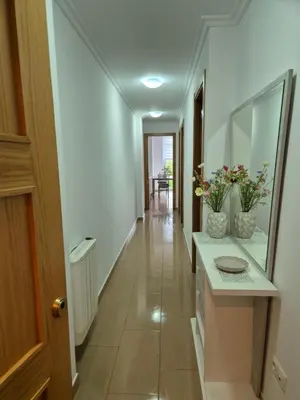 a hallway of a house with a sink and flowers at Apartamento céntrico, tranquilo, buenas vistas in Ribadeo