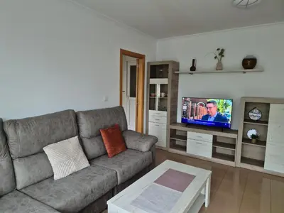 a living room with a couch and a flat screen tv at Apartamento céntrico, tranquilo, buenas vistas in Ribadeo