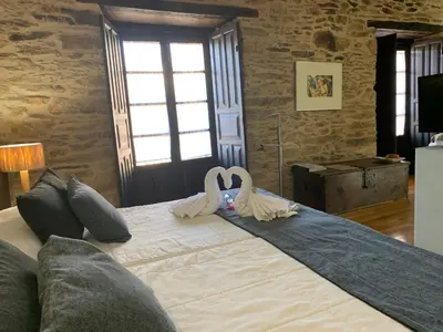 two swans shaped like hearts are sitting on a bed at Posada Real La Carteria in Puebla de Sanabria