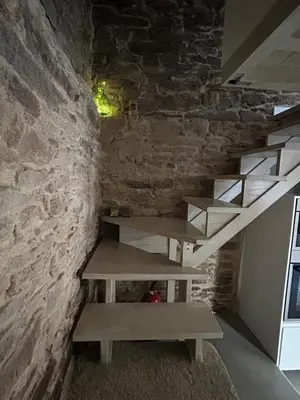a staircase in a room with a stone wall at Casa Agolada in Golada