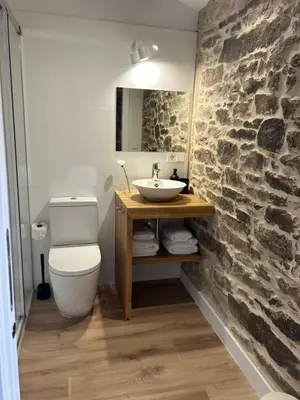 a bathroom with a sink and a stone wall at Casa Agolada in Golada