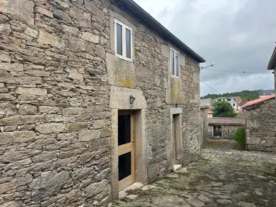 a stone building with two doors on it at Casa Agolada in Golada