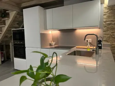 a kitchen with white cabinets and a sink with a faucet at Casa Agolada in Golada