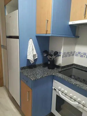 a small kitchen with blue cabinets and a stove at Almar in Ribadeo