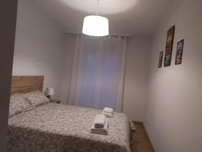 a small bedroom with a bed and a light at Almar in Ribadeo