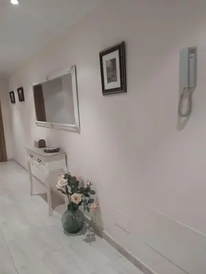 a white room with a vase with flowers in it at Almar in Ribadeo