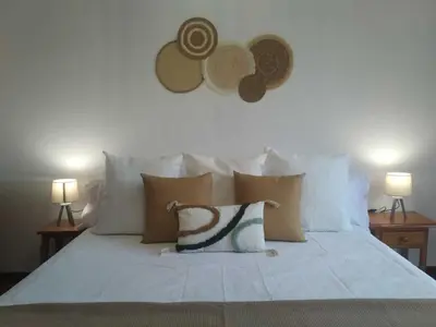 a white bed with pillows and hats on the wall at Apartamento Ziralla- con Garaje Gratis in Allariz