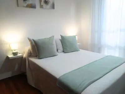 a bedroom with a large bed with two pillows at Apartamento Ziralla- con Garaje Gratis in Allariz