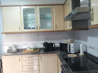 a kitchen with white cabinets and a microwave at Apartamento Ziralla- con Garaje Gratis in Allariz