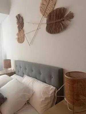 a bedroom with a bed with white pillows and a clock on the wall at La casa de Elena con terraza en el centro in Lugo