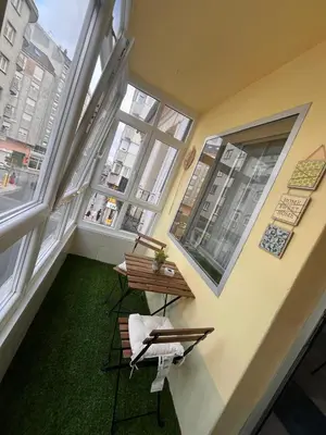 a room with two chairs and a table and windows at La casa de Elena con terraza en el centro in Lugo