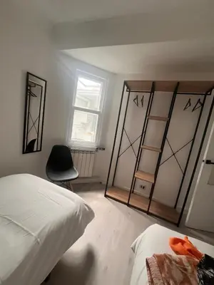 a bedroom with a bed and a mirror and a chair at La casa de Elena con terraza en el centro in Lugo