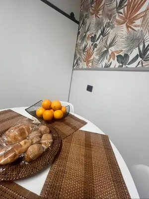 a table with a plate of bread and oranges on it at La casa de Elena con terraza en el centro in Lugo
