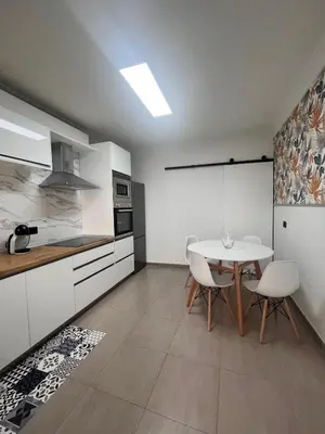 a kitchen with a table and chairs in a room at La casa de Elena con terraza en el centro in Lugo