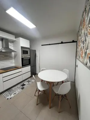 a kitchen with a table and chairs in a room at La casa de Elena con terraza en el centro in Lugo