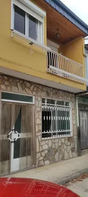 a yellow building with a door and a balcony at Casa SANTALLA in O Barco de Valdeorras