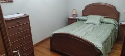 a bedroom with a bed and a dresser with a lamp at Casa SANTALLA in O Barco de Valdeorras